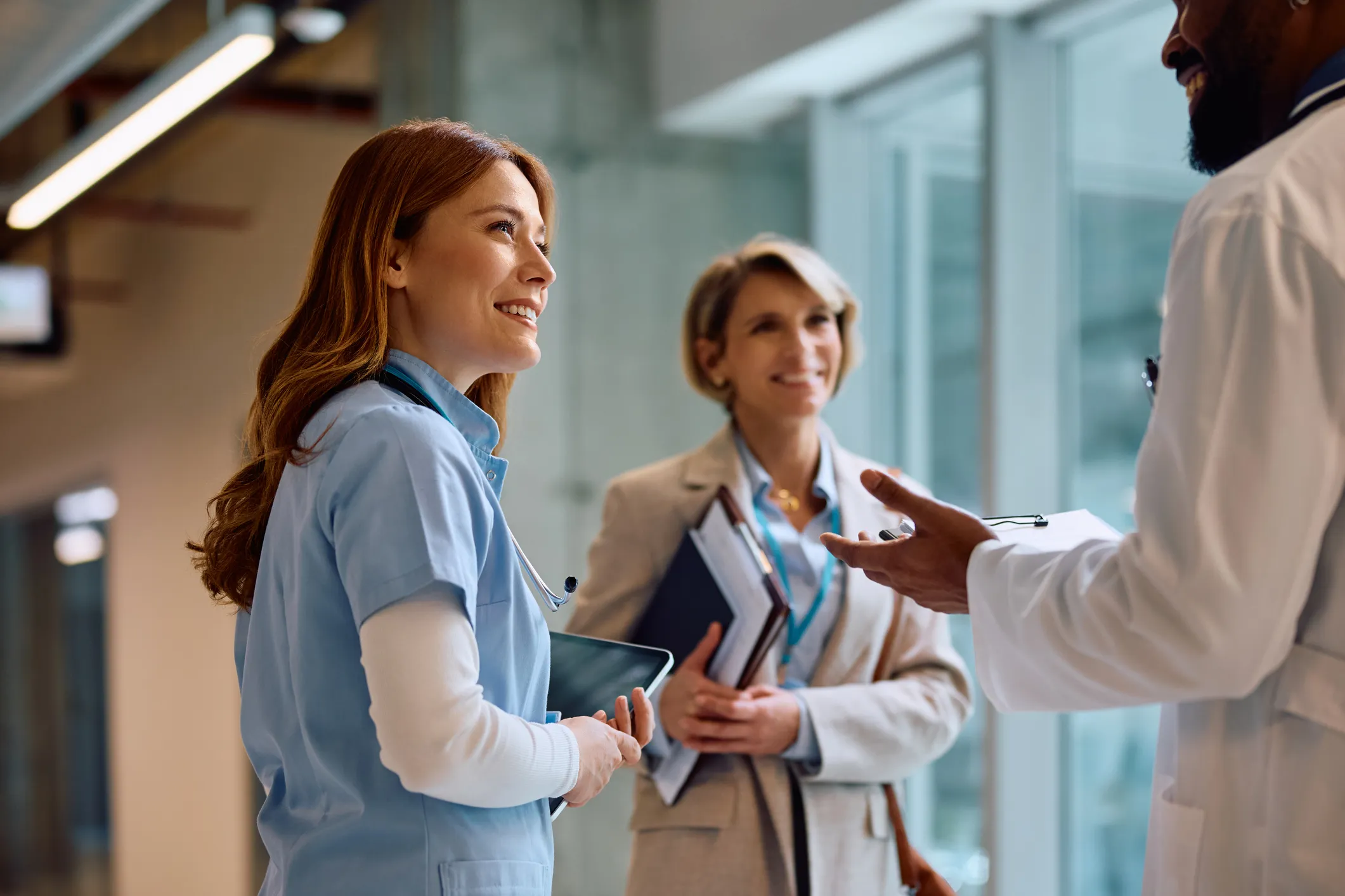 Healthcare professionals discussing in a hospital corridor.