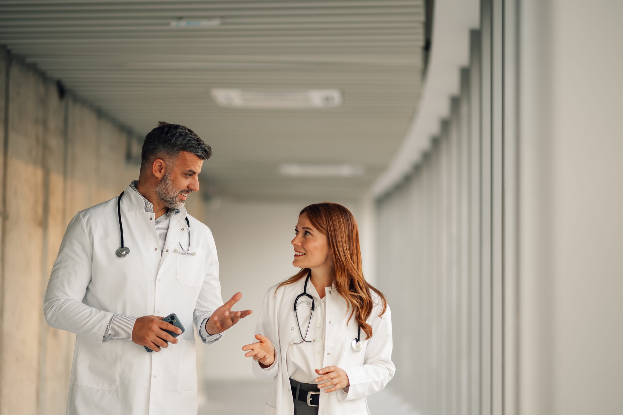 Doctors walking and discussing in hospital corridor.